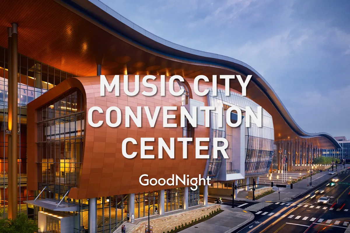 The distinctive wavy roof and large glass windows of the Music City Convention Center, set against an energetic and welcoming city backdrop. The modern architectural design is visually striking and immediately recognizable as a key business venue.